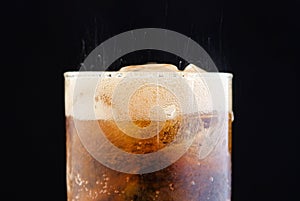 Ice cube in fizzy splashing water with soda