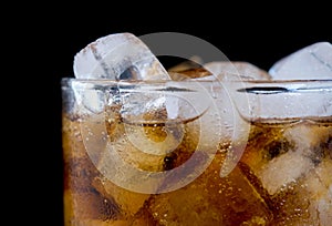 Ice cube in fizzy splashing water with soda