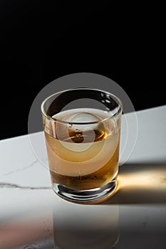 Ice cube in glass of whiskey