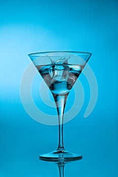 Ice cube splashing martini cocktail