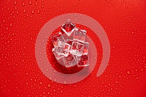 Ice cube with water drops on a red background