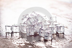 Ice cube on wooden table and light blurred background