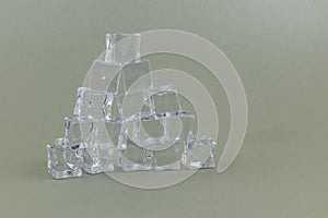 Ice cubes arranged in a pyramid shape on a plain background
