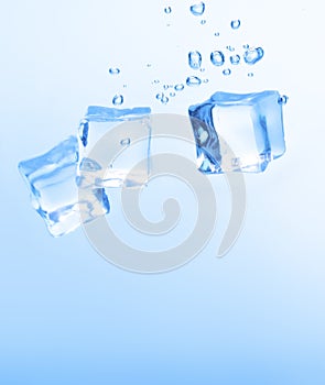 Ice cubes in blue water create bubbles that float to the surface