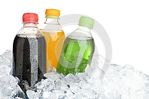 Ice cubes and different soda drinks on background