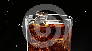 Ice cubes float in a glass of refreshing cola