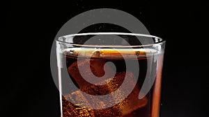 Ice cubes float in a glass of refreshing cola