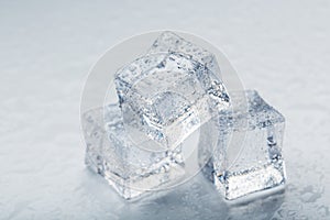 Ice cubes in the form of a pyramid with water drops close - up in macro on a white background