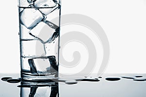 Ice cubes in fresh drinking water in glass on white background