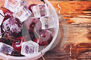Ice cubes, frozen ripe cherry in cup, macro