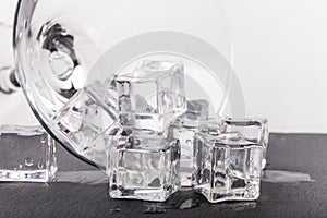 Ice cubes and martini glass on white background