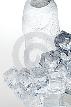 Ice cubes and mineral water bottle close-up