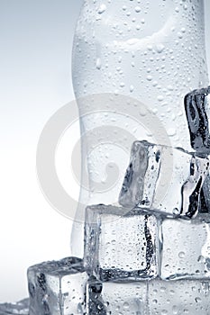 Ice cubes and mineral water bottle close-up