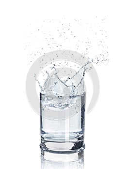 Ice cubes splashing into glass of water,