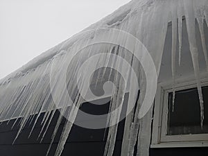 Ice dam and icicles on house in cold region in the winter.