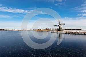 Ice on the Dieperpoel Kagerplassen in front of a windmill de Kok and house on the Kogjespolder