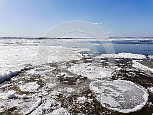 Ice drift on the river in spring. Embankment in the city of Saratov. Sunny day in April