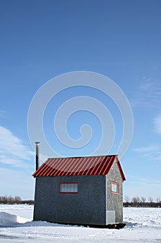 Ice fishing hut under the blue sky