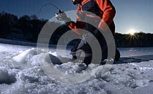 Ice fishing on a lake in winter