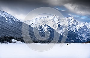 An ice fishing tent on a frozen lake in the Canadian Rockies near Banff Alberta.