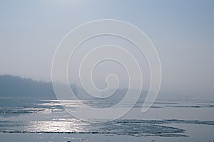 Ice floating in the river. Ice Break up. Sun reflection