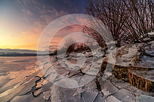 Ice floes on the lake shore. Colorful sky during sunrise on cold winter morning.Dam Liptovska Mara, Slovakia