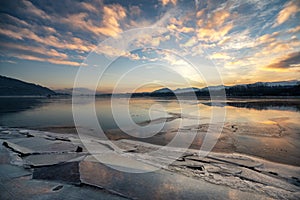 Ice floes on the lake shore. Colorful sky during sunrise on cold winter morning.Dam Liptovska Mara, Slovakia