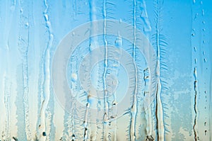 Ice flowers and frost pattern on frosty window glass