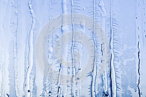 Ice flowers and frost pattern on frosty window glass