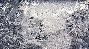 Ice flowers frozen on window. Winter cold textured pattern. Macro view. Frost crystal.