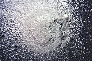 Ice flowers frozen on window. Winter cold textured pattern. Macro view. Frost crystal.