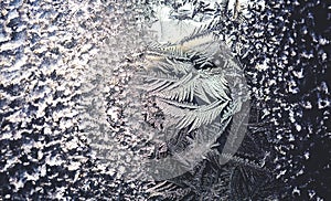 Ice flowers frozen on window. Winter cold textured pattern. Macro view. Frost crystal.