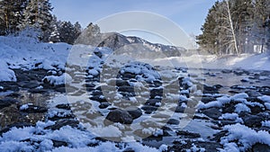 The ice-free river flows along a rocky bed.