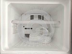 The ice is in the freezer compartment of the refrigerator.