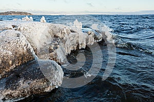 Ice frozen over rocks in lake shore