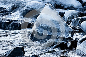 Ice frozen over rocks in lake shore