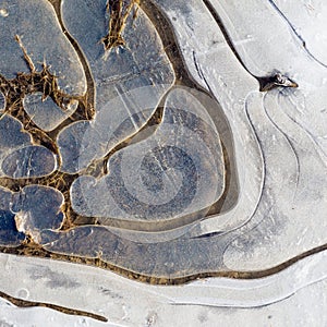 Ice Frozen Puddle on the Gravel Country Road