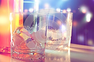 Ice in glass in nightlife with blurred background.
