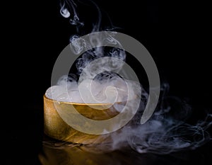 Ice in a golden box with smoke, colorful smoke, blue smoke, gray smoke, ice in syrup, delicious ice. space picture on dark backgro