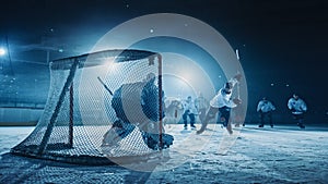 Ice Hockey Game in Rink Arena: Forward Player who Does Slapshot, Shoots Puck with Stick, Goalie photo