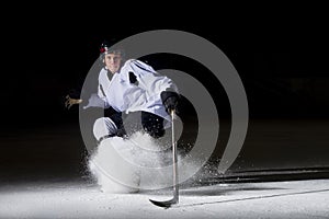 Ice hockey player in action kicking with stick