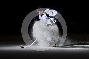 Ice hockey player in action kicking with stick