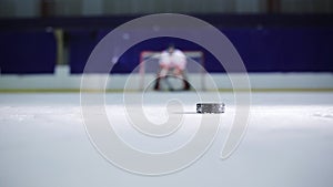 Ice hockey player holding a demonstration a free throw into the opponent`s gate Ice hockey puck and drove to her scores