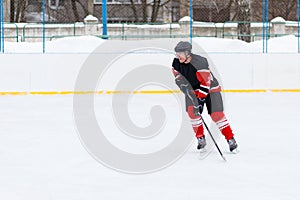 Ice hockey player with stick skating on the rink