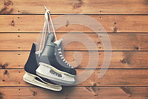 ice hockey skates hanging on nail on wooden background