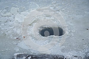 Ice hole in ice for winter fishing