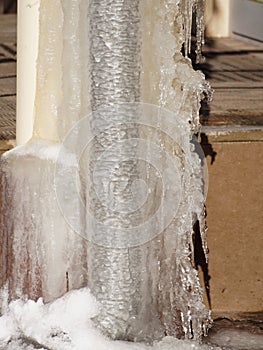 Ice and icicles on a drainpipe. Drainpipe covered with ice and icicles.