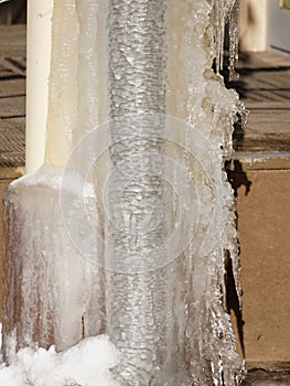 Ice and icicles on a drainpipe. Drainpipe covered with ice and icicles.