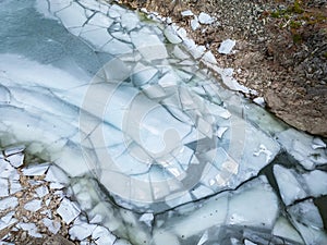 Ice at the lake by rocky shore. Aerial View. British Columbia landscape. Canada