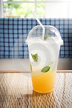 Ice lemon tea with mint and soda. In plastic cup. Refreshment drink.